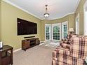 Cozy living room with bay windows, neutral carpet, and comfortable seating area at 443 Hillcrest Dr, Harrisburg, NC 28075