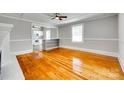 Spacious living room boasts gleaming hardwood floors, complemented by large windows and a ceiling fan at 514 Jones St, Chester, SC 29706