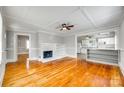 Inviting living room with a cozy fireplace and hardwood floors, open to kitchen, and a ceiling fan at 514 Jones St, Chester, SC 29706
