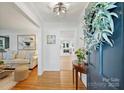 Inviting home foyer with hardwood floors, art, and decoratively trimmed passageways into the living room and kitchen at 5211 Londonderry Rd, Charlotte, NC 28210