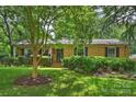 Charming brick home with a well-manicured lawn, classic shutters, and inviting front porch with an American flag at 5211 Londonderry Rd, Charlotte, NC 28210