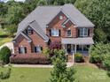 Aerial view showcasing the brick exterior and landscaped yard of this home at 6523 Alba Rose Ln, Huntersville, NC 28078
