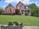 Charming two-story brick home with manicured lawn and inviting front porch at 6523 Alba Rose Ln, Huntersville, NC 28078
