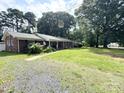 Inviting brick home with a well-maintained lawn, mature trees, and a walkway leading to the front door at 6539 Louglen Cir, Charlotte, NC 28212