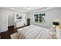 Well-lit bedroom with a large window, sleek furniture, and ensuite bathroom, virtually staged at 745 Erin Brook Ct, York, SC 29745
