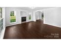 Spacious living room featuring dark wood floors, a cozy fireplace, and large windows at 745 Erin Brook Ct, York, SC 29745