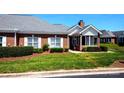 Attractive brick home with white trim, well-kept lawn and mature shrubbery at 8538 Highland Glen Dr, Charlotte, NC 28269