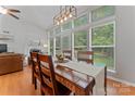 Inviting dining area with a wooden table, large windows offering backyard views, and modern lighting at 10043 Elsenham Ln, Charlotte, NC 28269