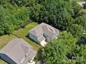 Aerial view of a lovely home with a lush green lawn surrounded by mature trees in a desirable neighborhood at 1008 Millbridge Pkwy, Waxhaw, NC 28173