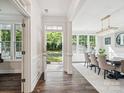 Bright foyer with hardwood floors leads to an elegant dining room with a stylish chandelier and abundant natural light at 1008 Millbridge Pkwy, Waxhaw, NC 28173