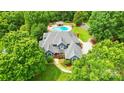 Beautiful home from above, showcasing a well-kept lawn, swimming pool, and mature landscaping at 1042 Heather Glen Dr, Matthews, NC 28104