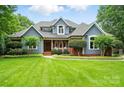 Charming two-story home with blue siding, manicured lawn, and beautiful landscaping at 1042 Heather Glen Dr, Matthews, NC 28104