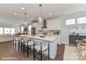 Spacious kitchen features an island with barstool seating, pendant lighting, and modern appliances with hardwood floors at 122 Wesser St # 14, Davidson, NC 28036