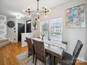 Elegant dining room with large windows, a modern chandelier, and a stylish wooden table at 12320 Verdant Ct, Charlotte, NC 28273