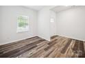 Clean, neutral room with wood-look floors, window, and white trim at 125 Fosters Glen Pl, Mooresville, NC 28115