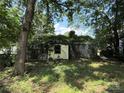 Overgrown exterior shows a dilapidated home with extensive vegetation and signs of neglect at 1317 Moretz Ave, Charlotte, NC 28206