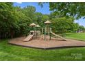 Community playground with multiple slides and play structures nestled among mature trees at 133 Fontanelle Dr, Mooresville, NC 28115