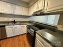 Functional kitchen with white cabinets, grey countertops, and stainless steel appliances at 1600 Sharon W Rd # 16, Charlotte, NC 28210