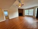 Spacious living room with brick fireplace, ceiling fan, and abundant natural light at 1600 Sharon W Rd # 16, Charlotte, NC 28210