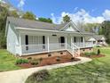 Charming one-story home with white picket fence, light blue siding, and brick foundation at 1675 Old Lynwood Cir, Lancaster, SC 29720