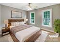 Comfortable bedroom with a ceiling fan, two windows, and a plush rug at 2027 Brook View Ct, Matthews, NC 28104