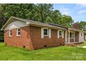 Brick house featuring classic shutters, a well-manicured lawn, and a cozy front porch at 2476 Cane Mill Rd, Lancaster, SC 29720