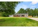 Inviting ranch-style home featuring a brick facade, attached garage, and a lush, green lawn at 2476 Cane Mill Rd, Lancaster, SC 29720