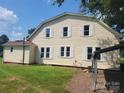 Two-story home shows many white framed windows and light yellow vinyl siding in backyard at 275 Hiddenite Church Rd, Hiddenite, NC 28636