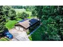 Aerial view of a home with a two-car garage, tree-lined yard, and proximity to a golf course at 3135 Lake Shore S Rd, Denver, NC 28037