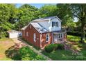 Traditional home with detached garage, mature trees, and well-maintained landscaping at 317 Campus St, Charlotte, NC 28216