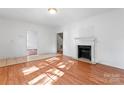 Bright living room boasts a fireplace and neutral walls with hardwood flooring at 317 Campus St, Charlotte, NC 28216