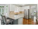 Well-lit kitchen featuring granite countertops, stainless steel appliances, and white cabinets at 4312 Beech Wood Ct, Belmont, NC 28012