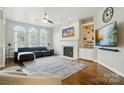 Bright living room featuring hardwood floors, fireplace, built-in shelving and many windows at 4312 Beech Wood Ct, Belmont, NC 28012