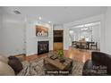 Cozy staged living room with a fireplace and open dining area at 435 Hurston Cir, Charlotte, NC 28208