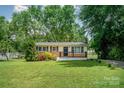 Charming single-story home featuring lush landscaping and a welcoming front porch with black railing at 4720 Randleman Rd, Conover, NC 28613
