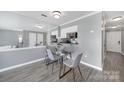 Dining area with gray walls, modern light fixture, and a view into the kitchen with sleek black counters at 502 Heritage Pkwy, Fort Mill, SC 29715
