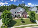 Striking exterior of a home with stone and siding, a lush green lawn, and vibrant red shutters at 510 Placid Ct, Tega Cay, SC 29708