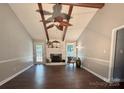 Spacious living room with exposed ceiling beams, hardwood flooring, and a traditional white fireplace at 5916 Indian Brook Dr, Matthews, NC 28104