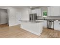 Well-designed kitchen boasts a large island, granite countertops, stainless steel appliances, and sleek white cabinets at 7311 Jerimoth Dr, Charlotte, NC 28215
