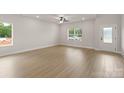 Bright living room featuring light wood floors, white walls, and large windows offering a clean and spacious ambiance at 7311 Jerimoth Dr, Charlotte, NC 28215