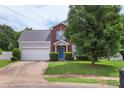 Inviting home with blue door and shutters, red brick, light grey siding, and 2-car attached garage at 8904 Gerald Dr, Charlotte, NC 28217