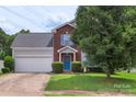 Attractive two-story home with brick accents, blue shutters, an attached 2-car garage, and manicured landscaping at 8904 Gerald Dr, Charlotte, NC 28217