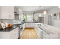 Bright, all-white kitchen featuring an island with marble countertop, stainless steel appliances, and hardwood floors at 1011 Westbrook Dr # A, Charlotte, NC 28202