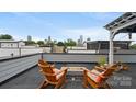 Rooftop deck with comfortable chairs and fire pit overlooking city skyline at 1011 Westbrook Dr # A, Charlotte, NC 28202