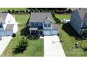 Aerial view of a charming home with a spacious driveway, landscaped yard, and backyard fence at 1019 Beacon Ave, Monroe, NC 28110