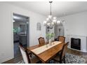 Formal dining room featuring a decorative chandelier, wooden table, and view into kitchen at 1019 Beacon Ave, Monroe, NC 28110