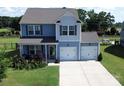 Charming two-story home with a two-car garage, featuring light blue siding and a well-manicured lawn at 1019 Beacon Ave, Monroe, NC 28110