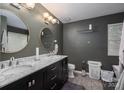 Bathroom with dual vanity, dark gray walls, modern fixtures, and stylish decor at 10925 Lassen Ct, Charlotte, NC 28214