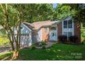 Charming home with brick and siding, front yard, and mature trees adding to its curb appeal at 10925 Lassen Ct, Charlotte, NC 28214