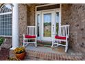 Inviting front porch with rocking chairs and decorative glass front door at 126 Doyle Farm Ln, Mooresville, NC 28115